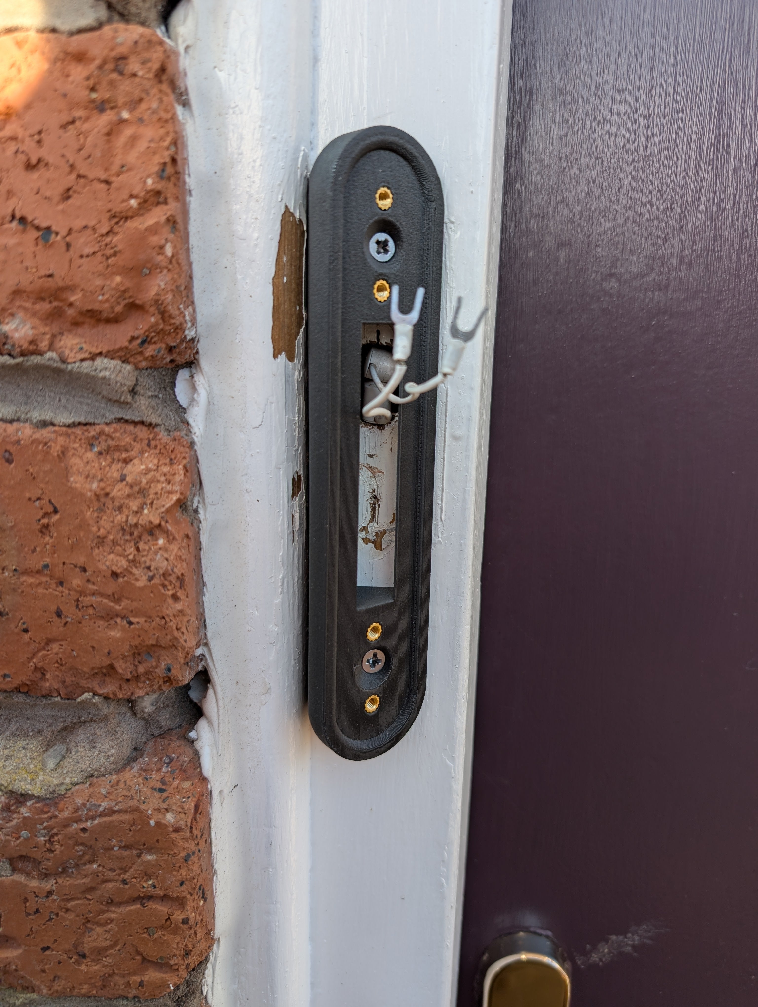 Google Nest Doorbell (Battery) Reversible Angle Mount, in grey. Mounted on door frame.