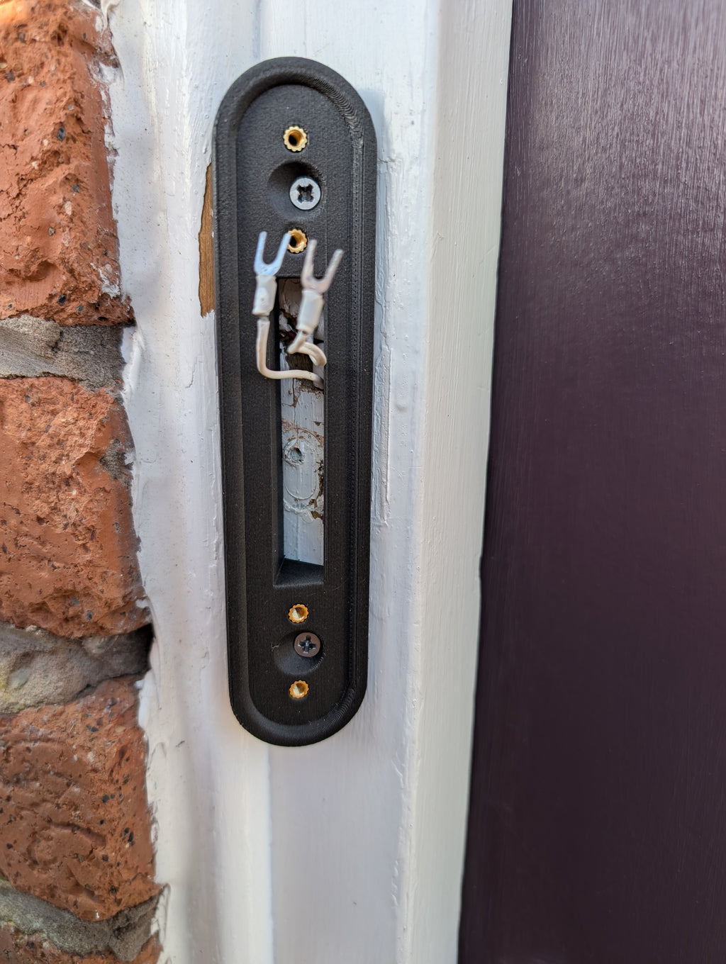 Google Nest Doorbell (Battery) Reversible Angle Mount, in grey. Mounted on door frame.