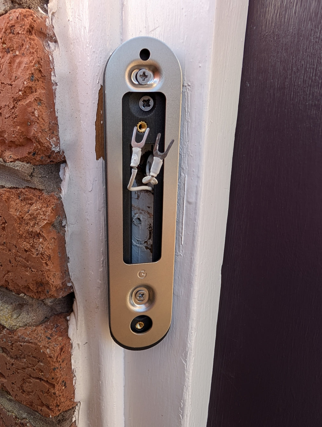 Google Nest Doorbell (Battery) Reversible Angle Mount, in grey. Mounted on door frame.