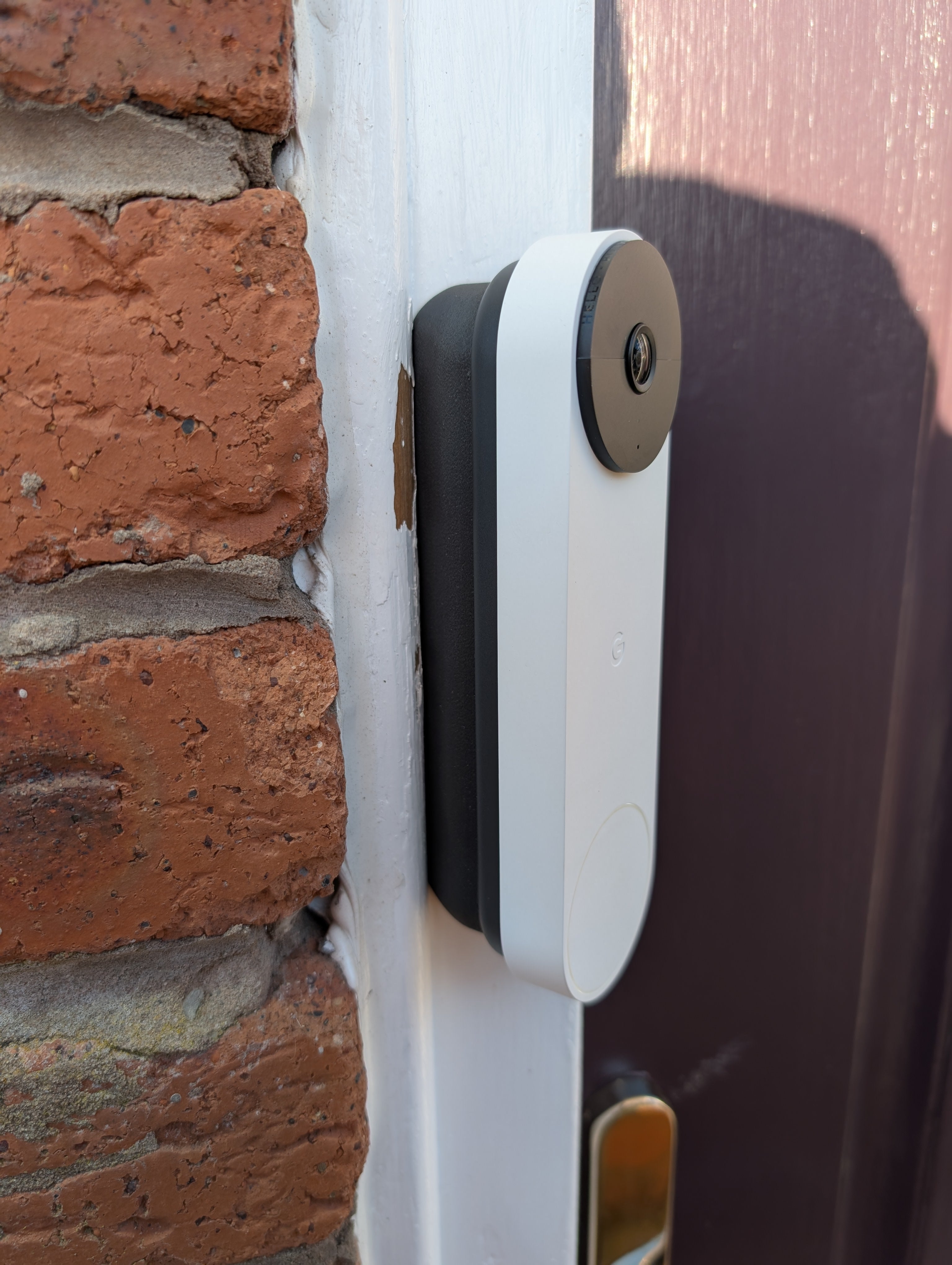 Google Nest Doorbell (Battery) Reversible Angle Mount, in grey. Mounted on door frame.