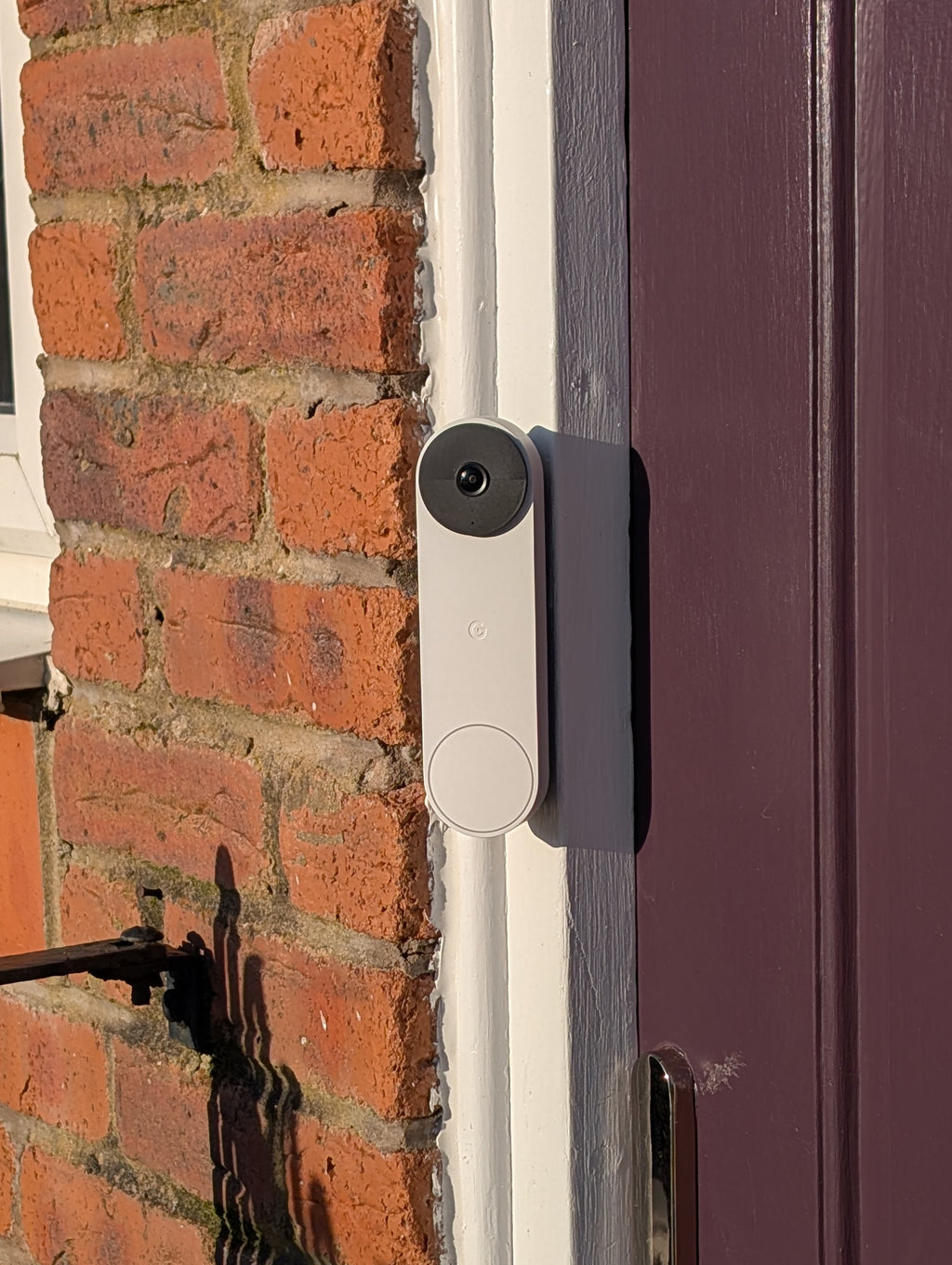 Google Nest Doorbell (Battery) Reversible Angle Mount, in grey. Mounted on door frame.