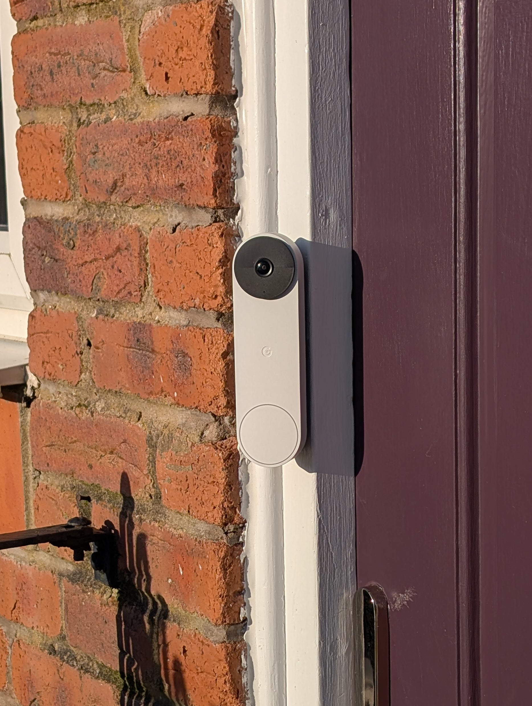 Google Nest Doorbell (Battery) Reversible Angle Mount, in grey. Mounted on door frame.