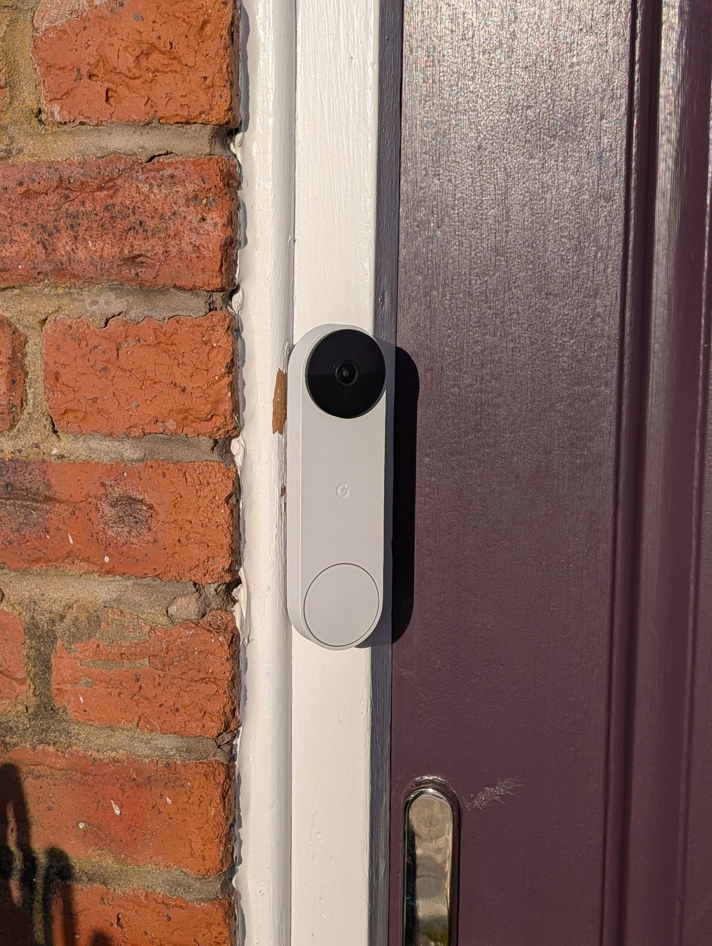 Google Nest Doorbell (Battery) Reversible Angle Mount, in grey. Mounted on door frame.