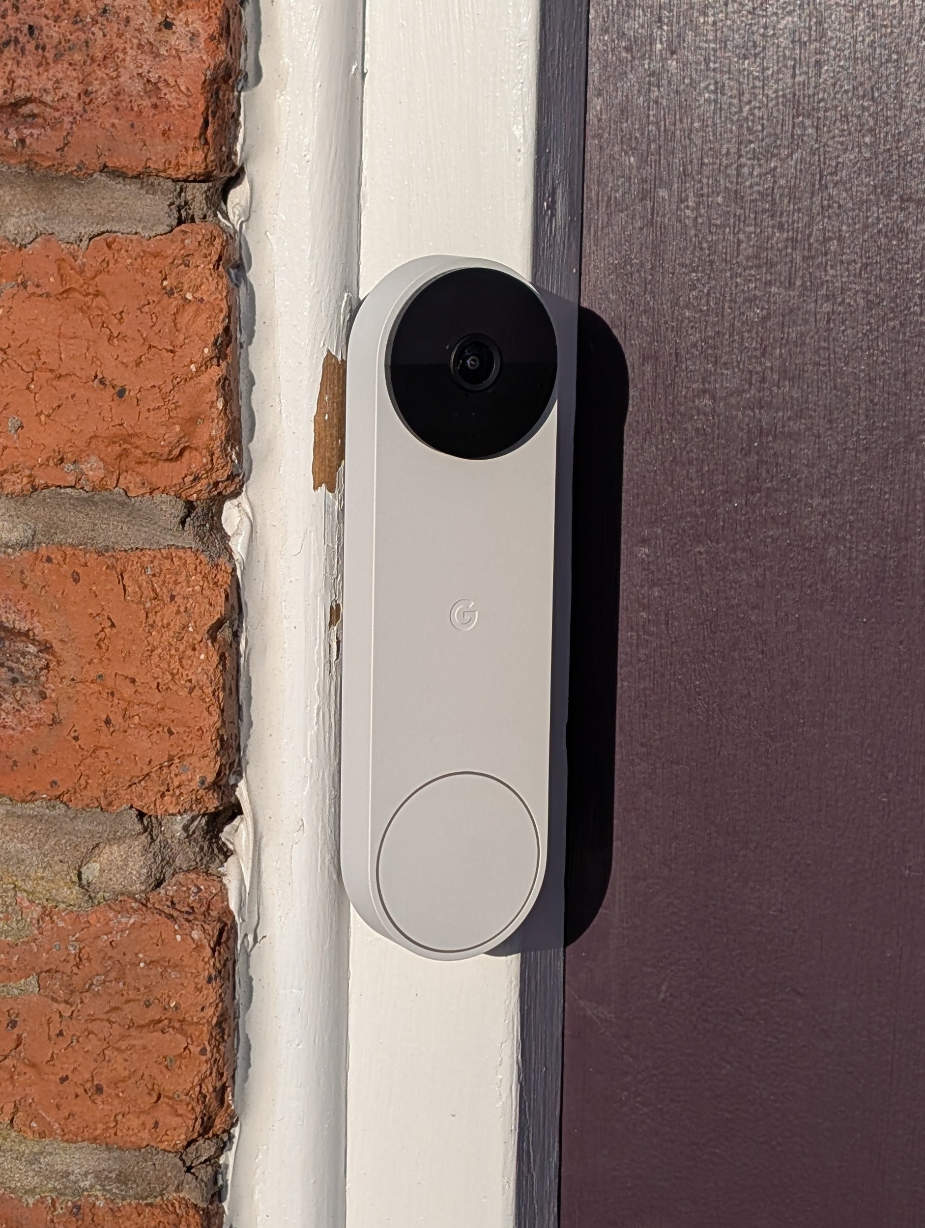 Google Nest Doorbell (Battery) Reversible Angle Mount, in grey. Mounted on door frame.