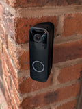Blink Video Doorbell (Version 1) Reversible Angle Mount, in black. Mounted on wall.