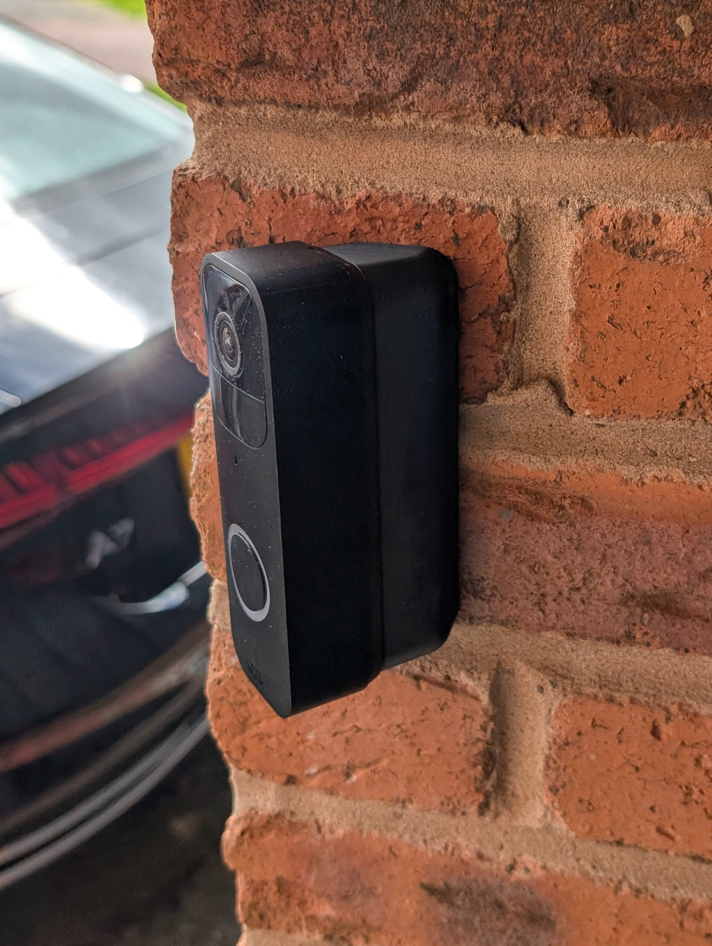 Blink Video Doorbell (Version 1) Reversible Angle Mount, in black. Mounted on wall.