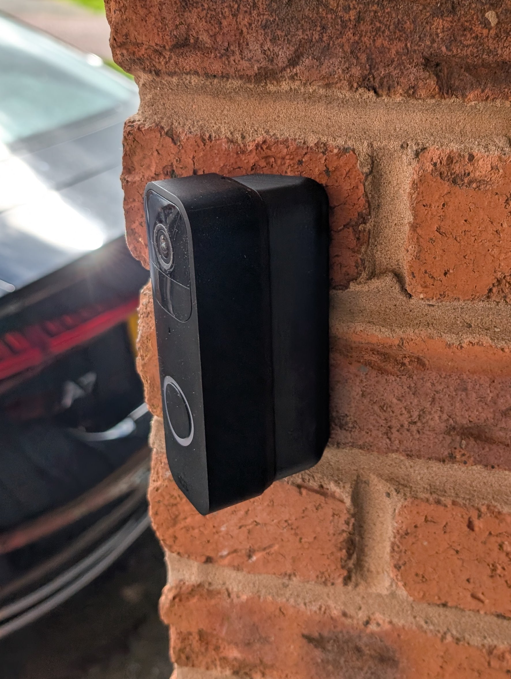 Blink Video Doorbell (Version 1) Reversible Angle Mount, in black. Mounted on wall.