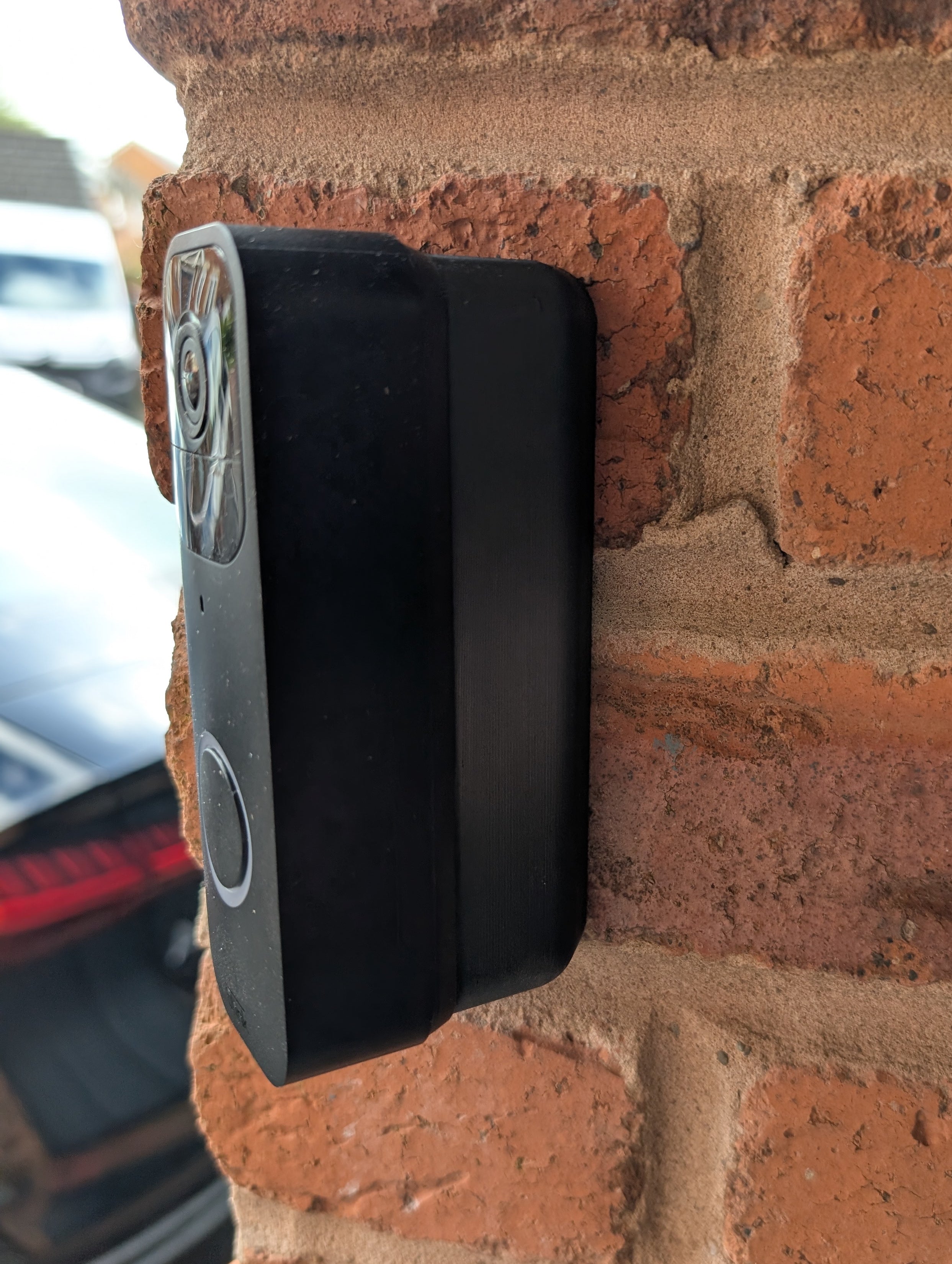 Blink Video Doorbell (Version 1) Reversible Angle Mount, in black. Mounted on wall.