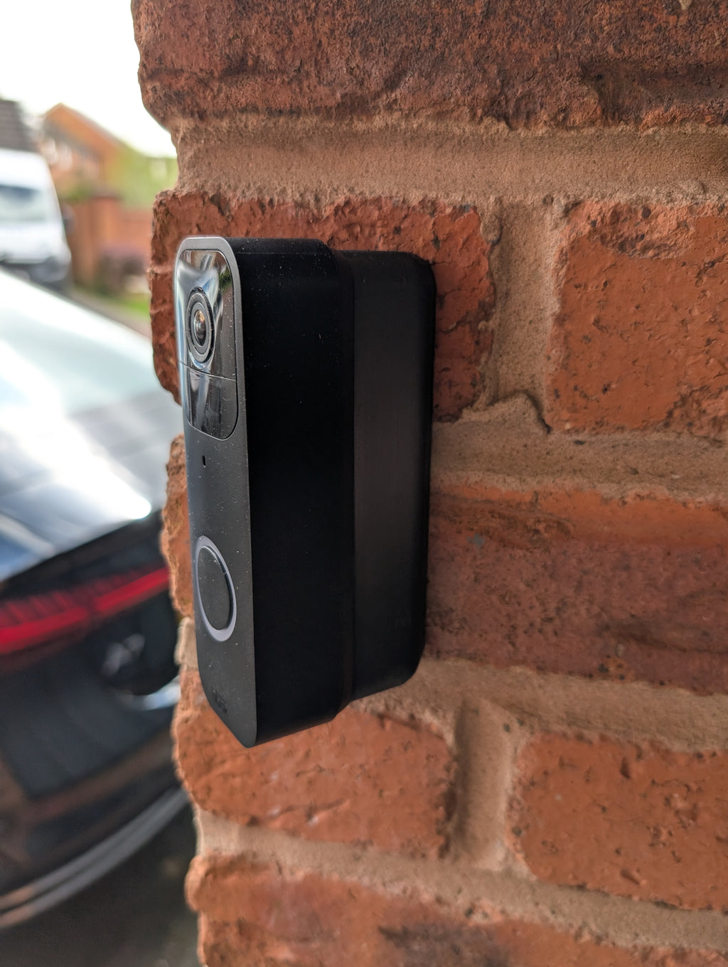 Blink Video Doorbell (Version 1) Reversible Angle Mount, in black. Mounted on wall.