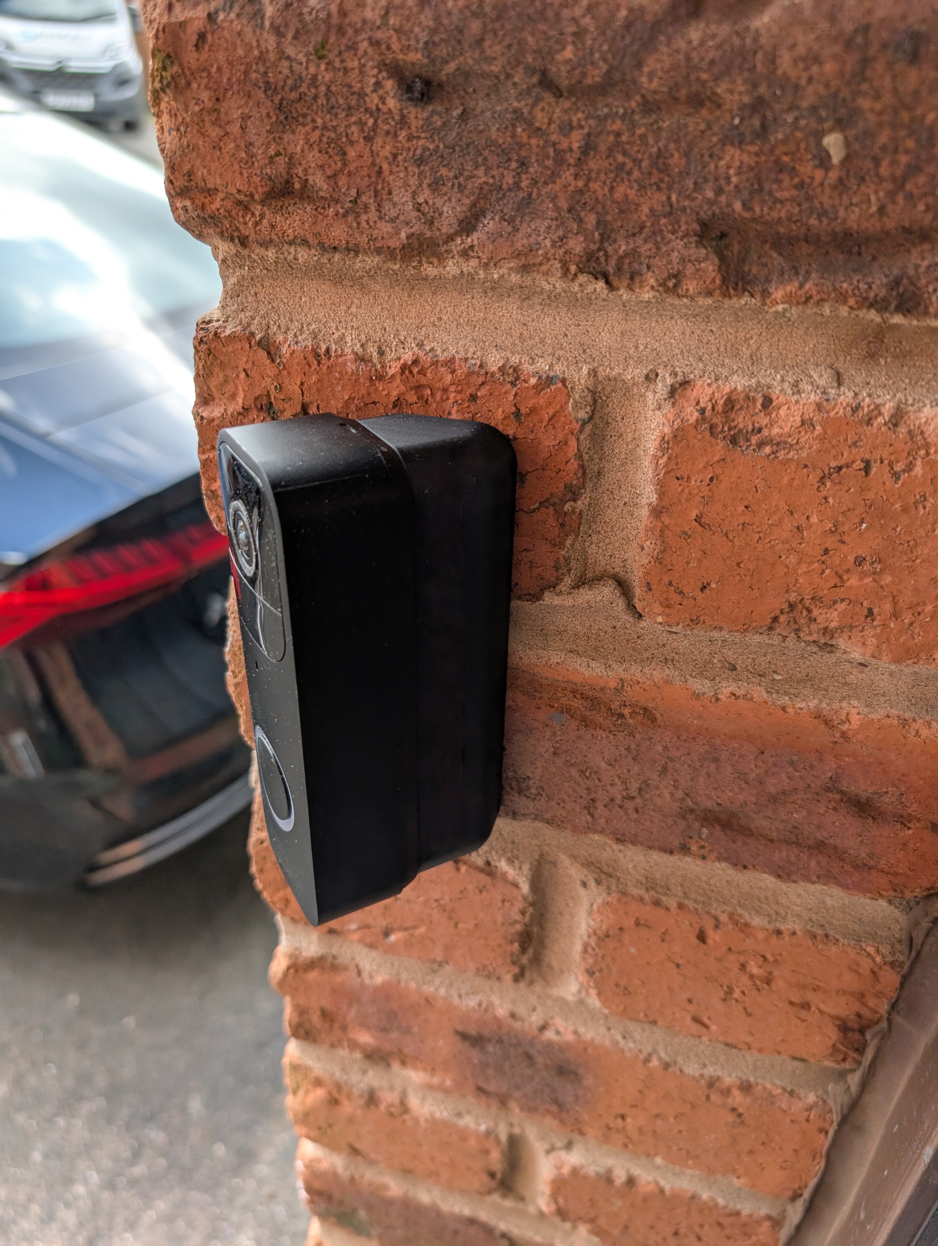 Blink Video Doorbell (Version 1) Reversible Angle Mount, in black. Mounted on wall.