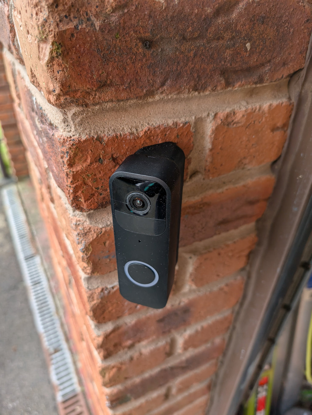 Blink Video Doorbell (Version 1) Reversible Angle Mount, in black. Mounted on wall.