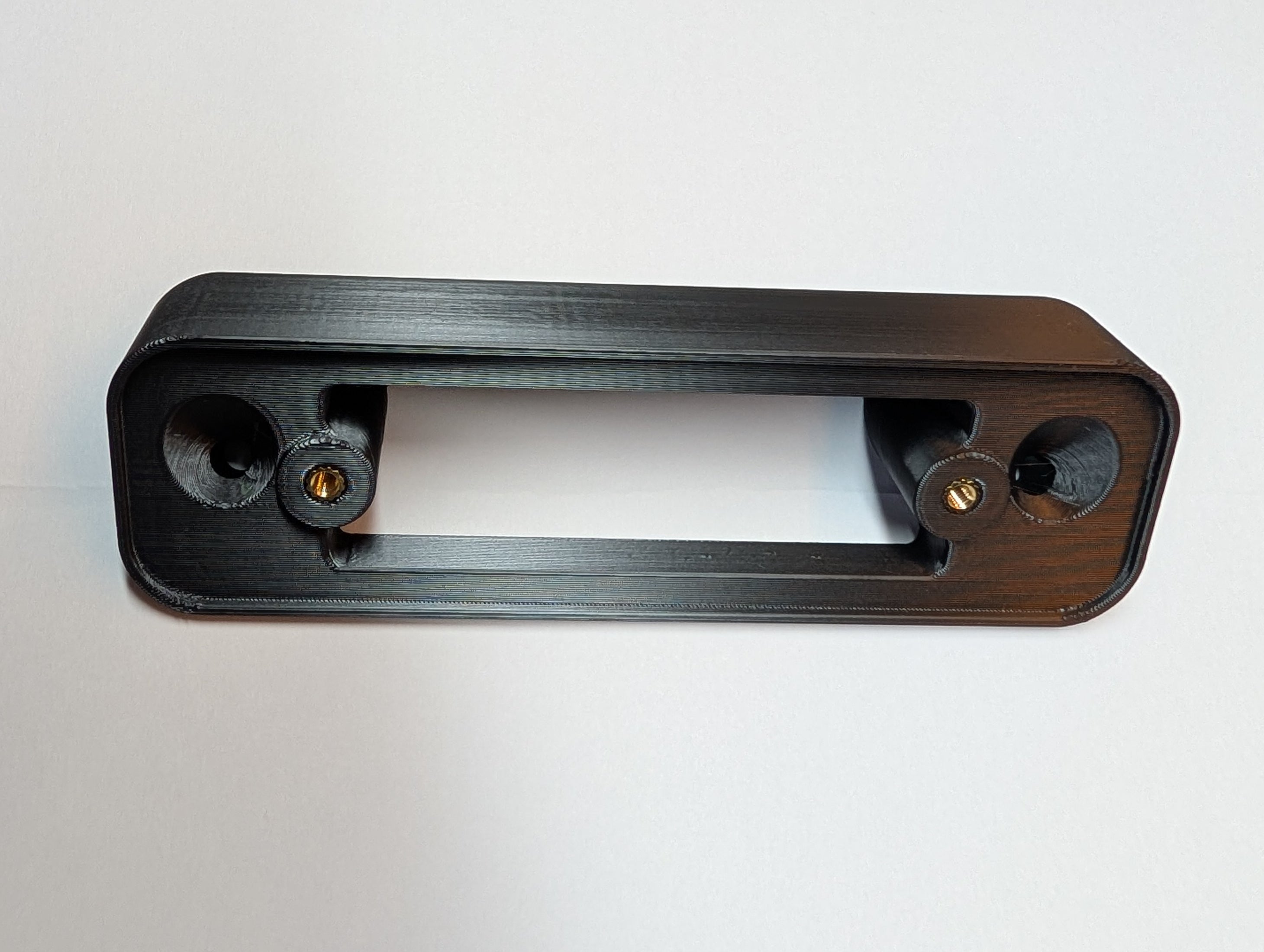 Blink Video Doorbell (Version 1) Reversible Angle Mount, in black. Unmounted on work surface.
