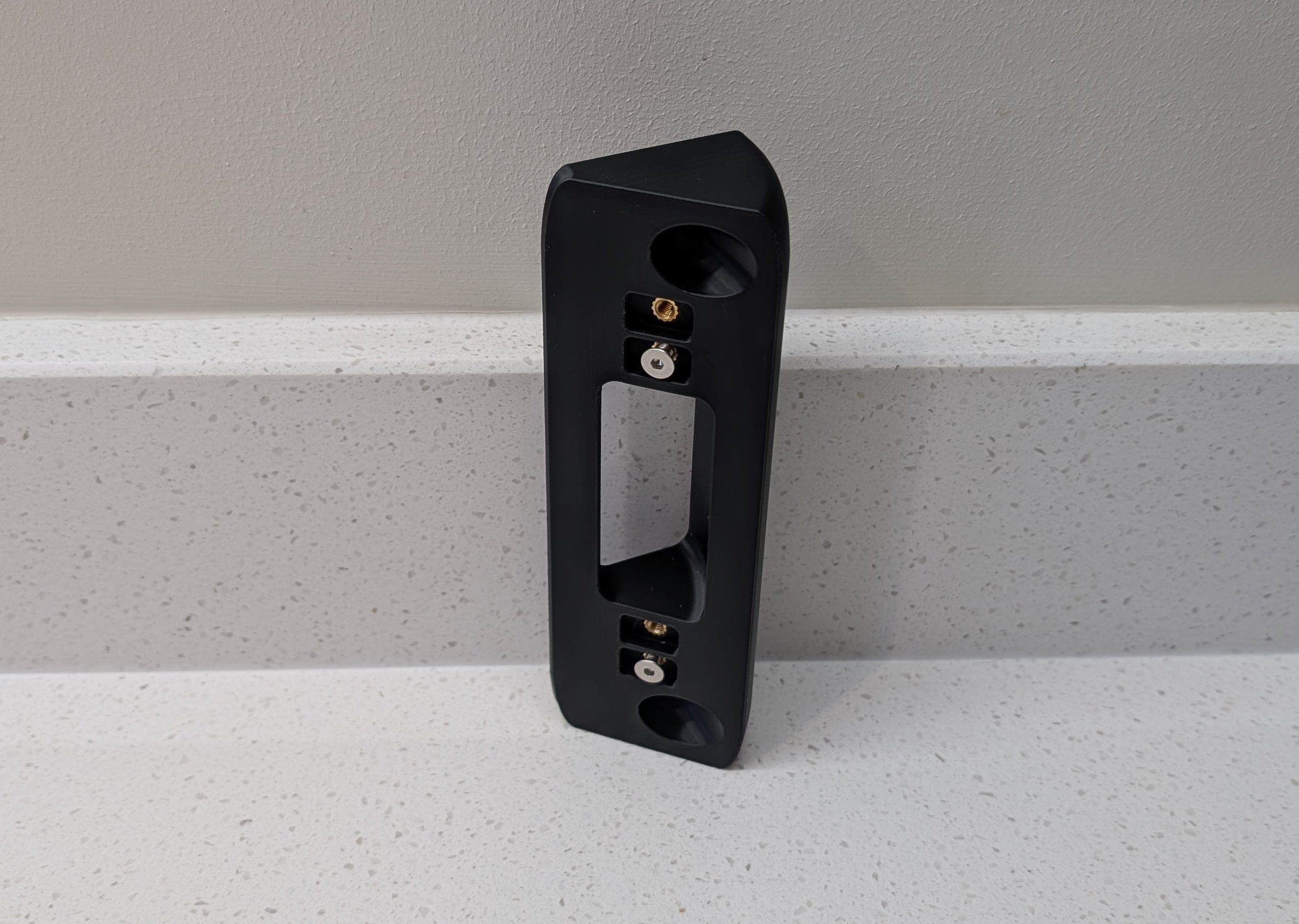 Eufy Video Doorbell Dual S330 Reversible Angle Mount, in black. Unmounted on worksurface.