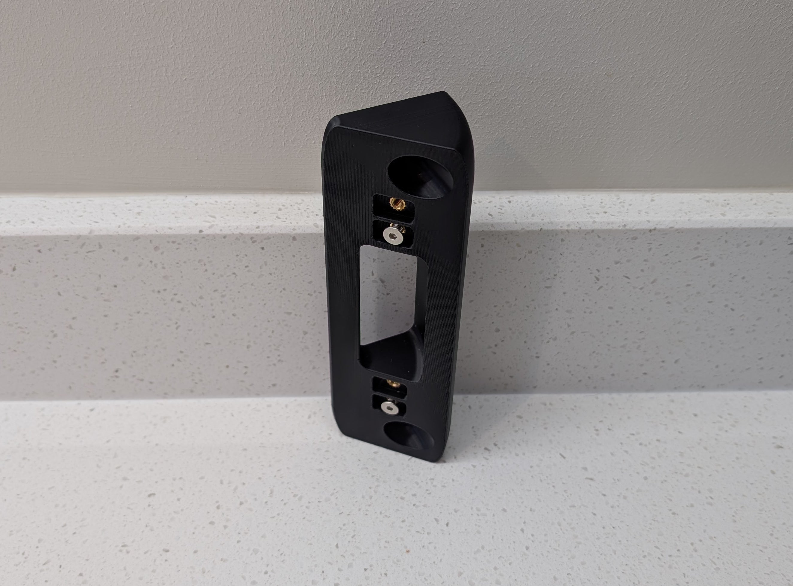 Eufy Video Doorbell Dual S330 Reversible Angle Mount, in black. Unmounted on worksurface.