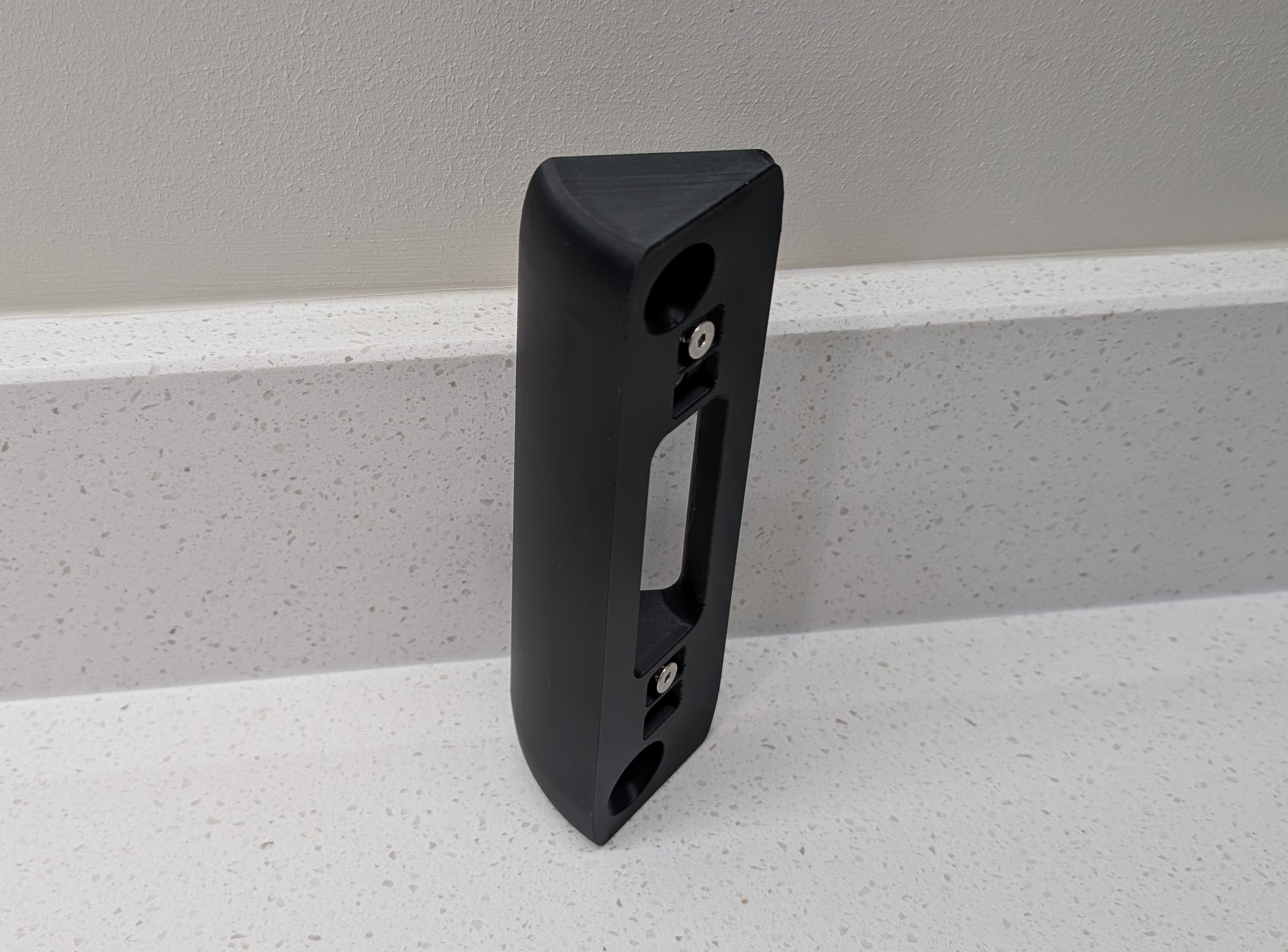 Eufy Video Doorbell Dual S330 Reversible Angle Mount, in black. Unmounted on worksurface.