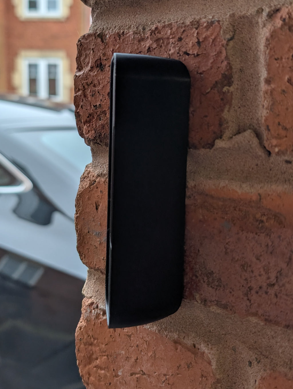 Blink Video Doorbell (2nd Gen) Reversible Angle Mount, in black. Mounted on wall.