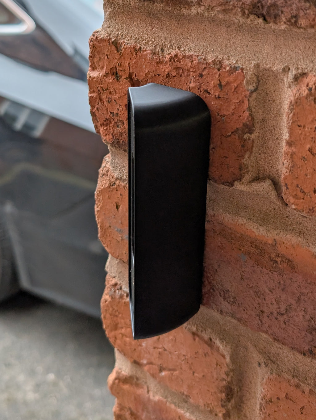 Blink Video Doorbell (2nd Gen) Reversible Angle Mount, in black. Mounted on wall.
