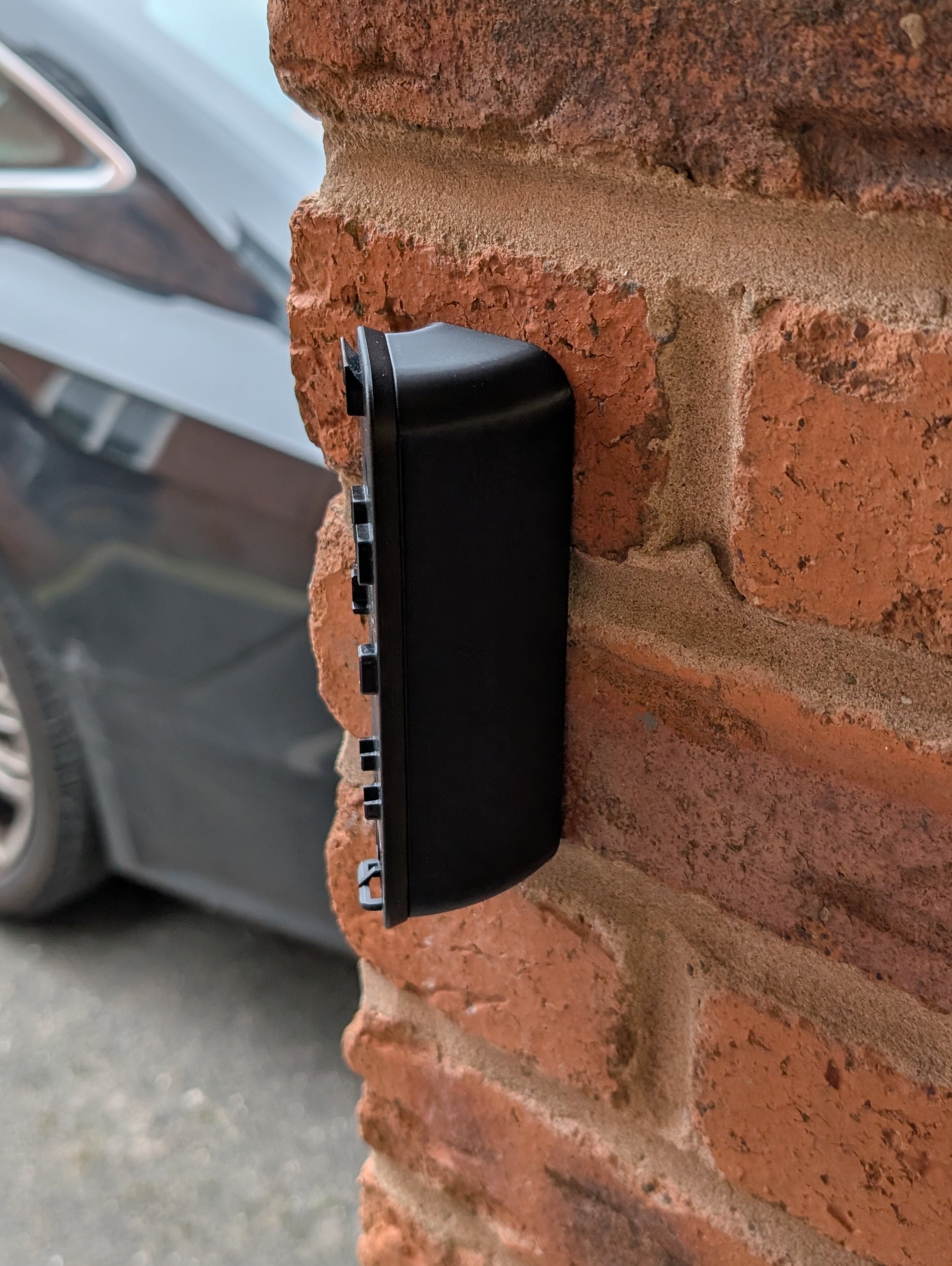 Blink Video Doorbell (2nd Gen) Reversible Angle Mount, in black. Mounted on wall.