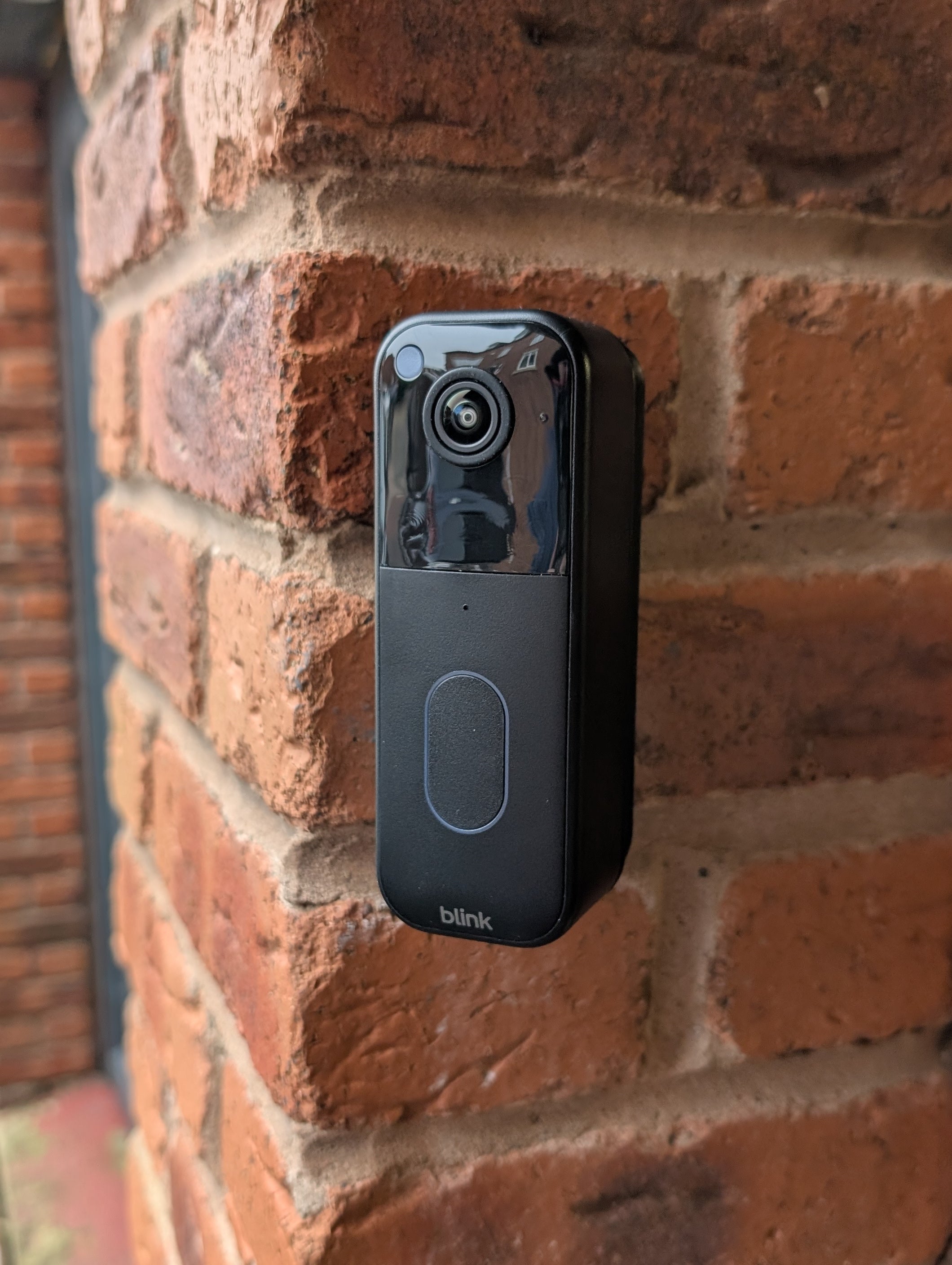 Blink Video Doorbell (2nd Gen) Reversible Angle Mount, in black. Mounted on wall.