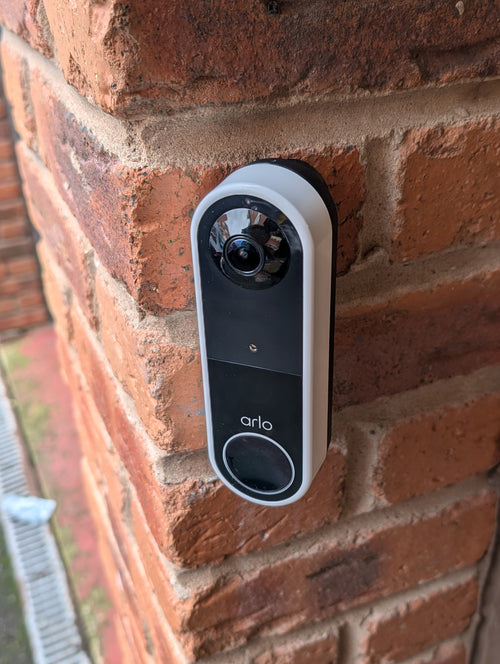 Arlo Essential Video Doorbell Gen 1 Reversible Angle Mount, in black. Mounted on wall.