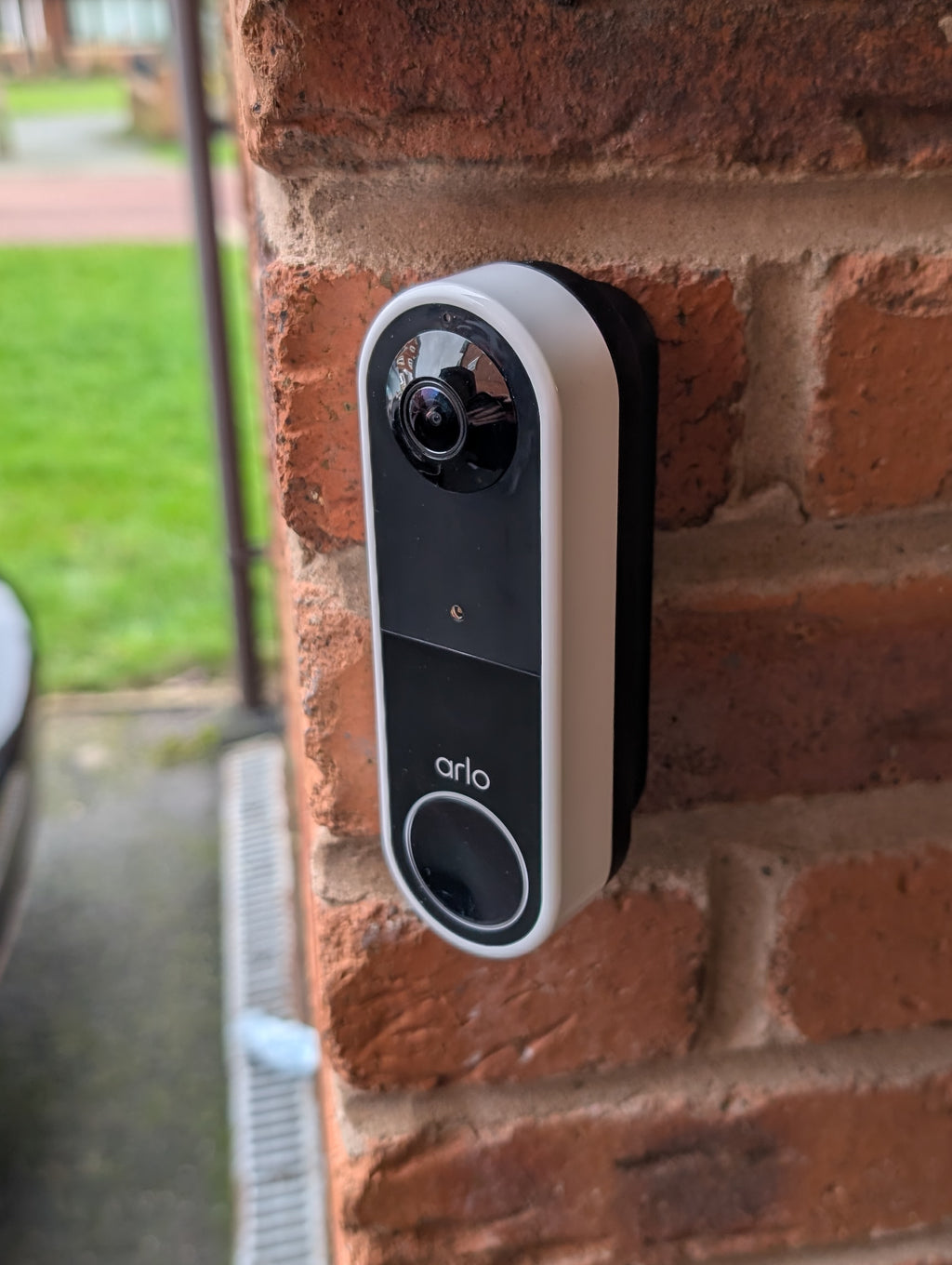 Arlo Essential Video Doorbell Gen 1 Reversible Angle Mount, in black. Mounted on wall.