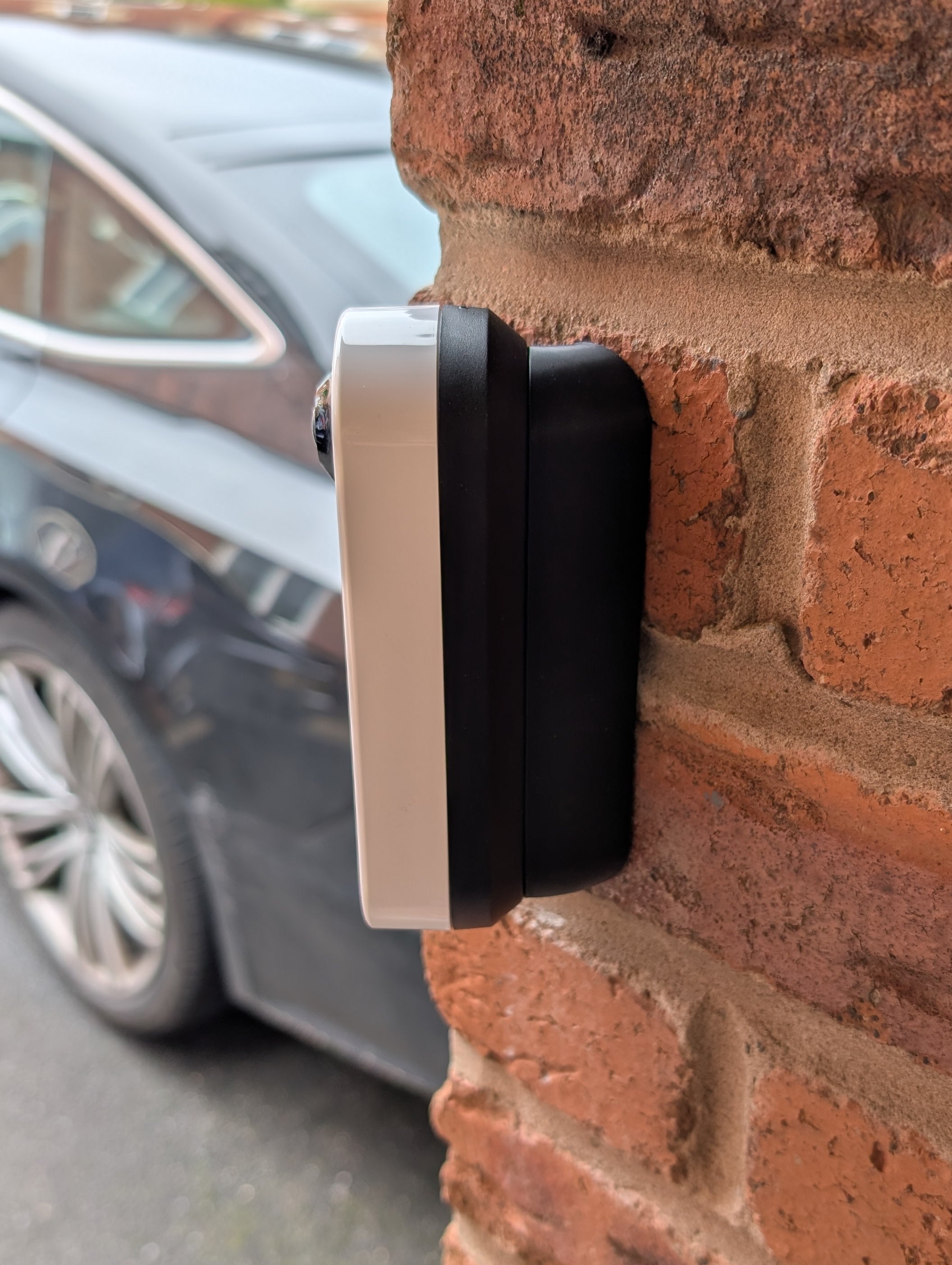 Arlo Essential Video Doorbell Gen 1 Reversible Angle Mount, in black. Mounted on wall.