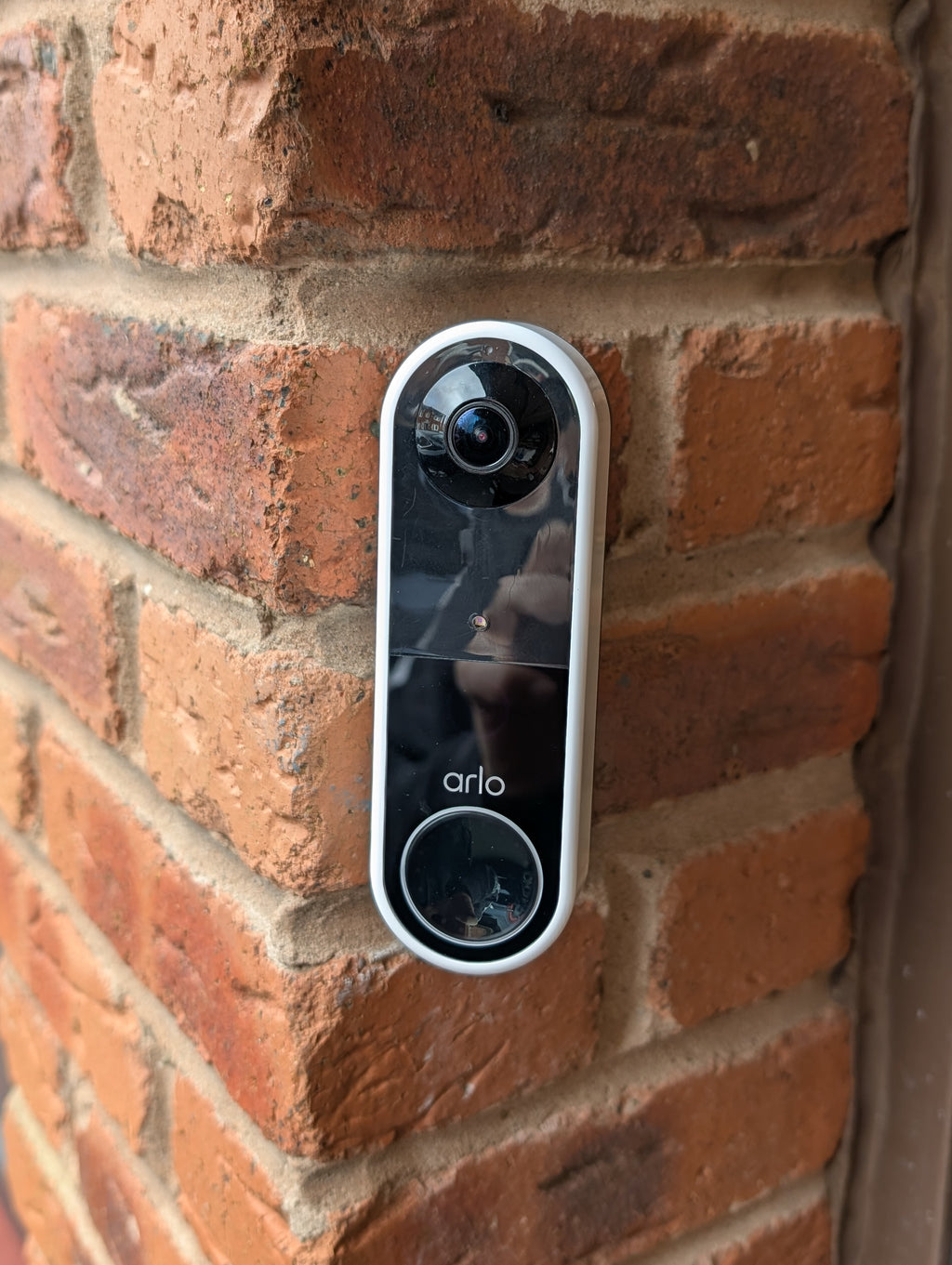Arlo Essential Video Doorbell Gen 1 Reversible Angle Mount, in black. Mounted on wall.