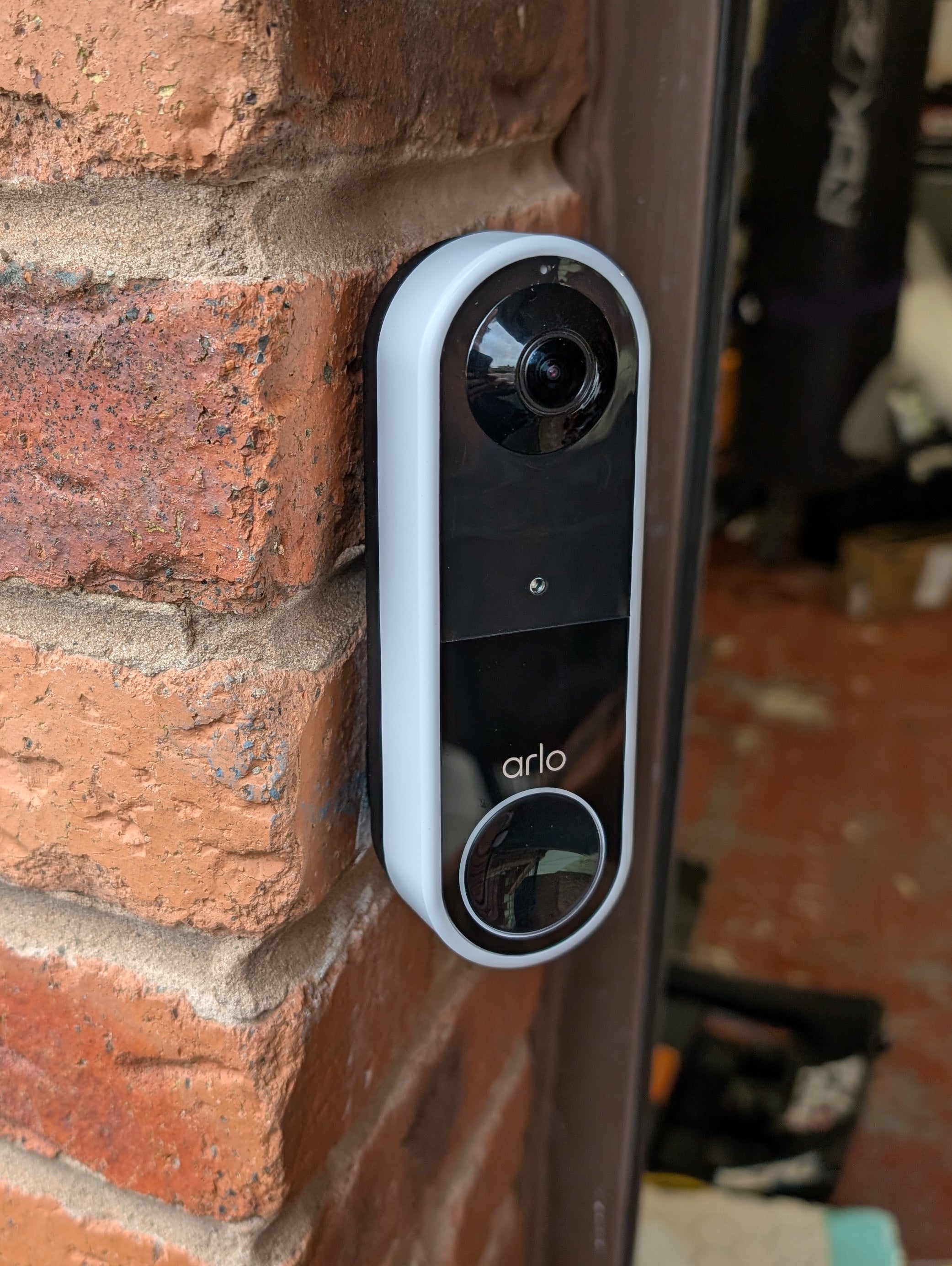 Arlo Essential Video Doorbell Gen 1 Reversible Angle Mount, in black. Mounted on wall.