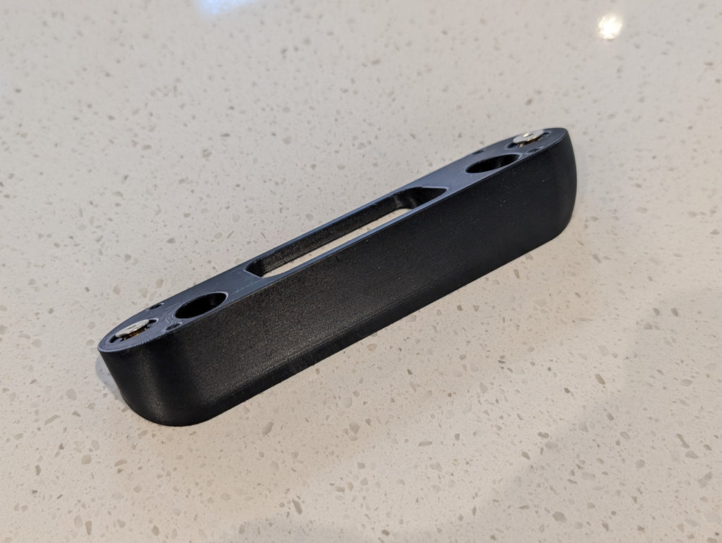 Arlo Essential Video Doorbell Gen 1 Reversible Angle Mount, in black. Unmounted on work surface.