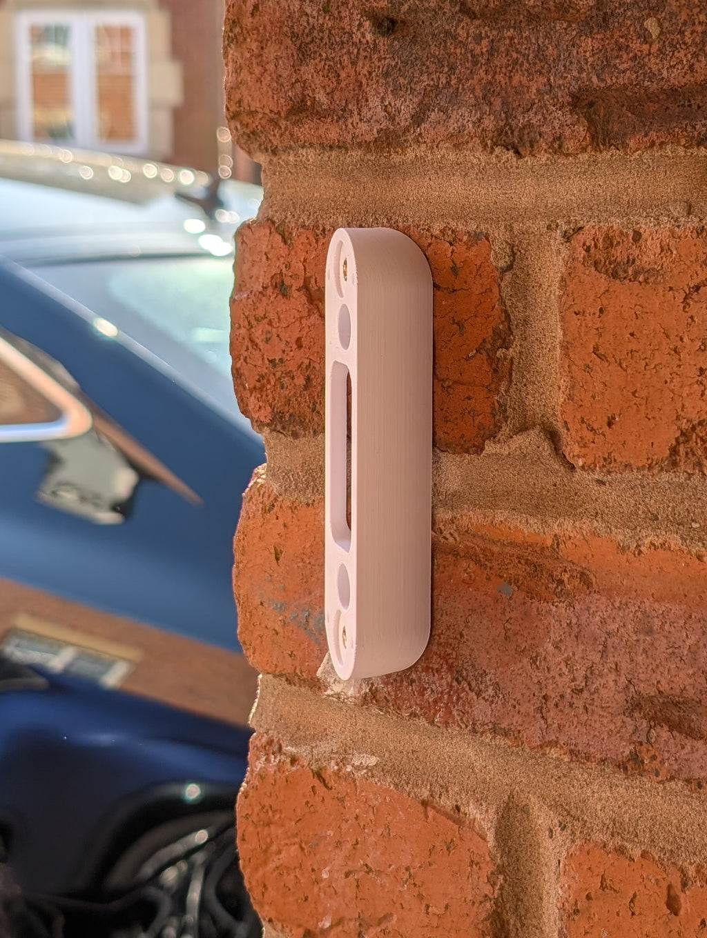 Angled wedge mount for Arlo Gen2 Doorbell, in white.